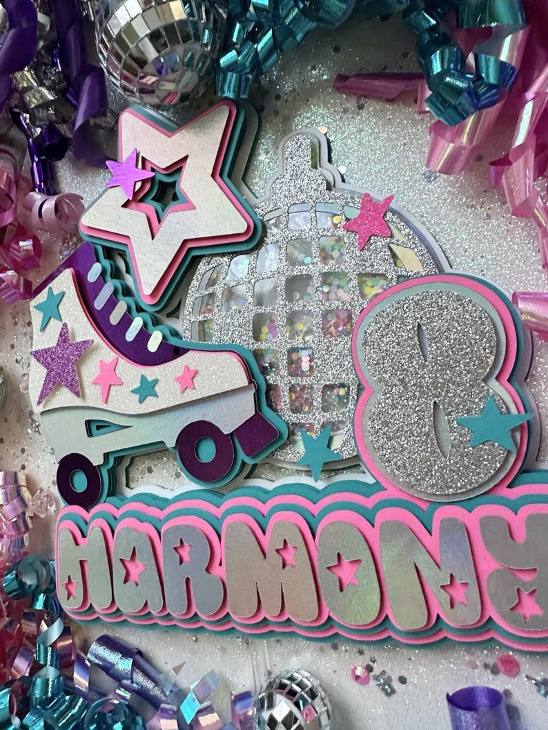 May include: A silver glitter roller skate with a pink and purple trim, a silver glitter disco ball, and a silver glitter number eight. The words "Harmony" are written in pink and white glitter letters with a teal border.