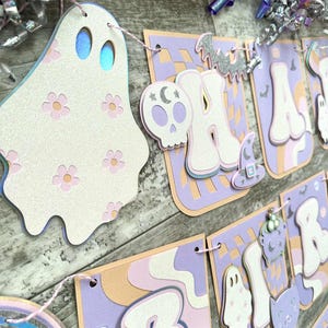 Banner de cumpleaños a cuadros estilo preppy con una flor fantasmal y espeluznante de Halloween en tonos pastel
