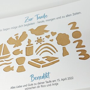 May include: A white card with a brown paper cut-out design. The design includes a dove, a sun, a rainbow, a tree, a chalice, a fish, a boat, and the numbers 2023. The text on the card reads "Zur Taufe", "Gottes Segen m&ouml;ge dich begleiten - heute, morgen und zu allen Zeiten.", "Benedikt", "Alles Liebe und Gute zu deiner Taufe am 15. April 2022", and "w&uuml;nschen dir Rico und Antje".