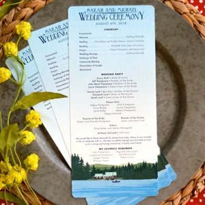 May include: A wedding ceremony program with a blue and white gradient background. The program lists the order of events, the wedding party, and the parents of the bride and groom. The program also includes a small illustration of a cabin on a lake.