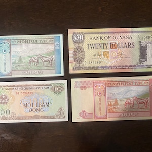 May include: Four different banknotes from Mongolia, Vietnam, and Guyana. The Mongolian banknotes feature a red and white design with the text "МОНГОЛ УЛСА" and "ТОГРОГ". The Vietnamese banknote features a yellow and red design with the text "CÔNG HÒA XÃ HỘI CHỦ NGHĨA VIETNAM" and "MOTTRAM ĐỒNG". The Guyanese banknote features a green and white design with the text "BANK OF GUYANA" and "TWENTY DOLLARS".