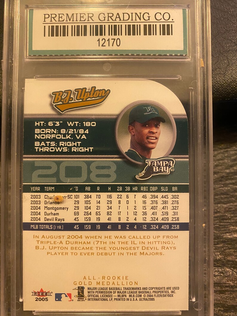 May include: A baseball card featuring a photo of baseball player B.J. Upton in a Tampa Bay Rays uniform. The card is from the 2005 Fleer Ultra series and features the text "All Rookie Gold Medallion".