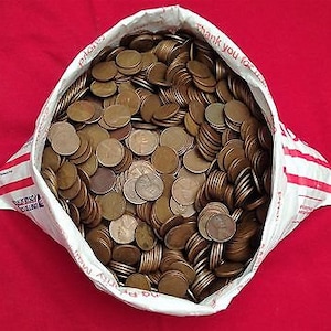 May include: A white and red striped padded envelope overflowing with a large quantity of copper-colored pennies. The coins are stacked and scattered, filling the bag. The background is a solid red surface.