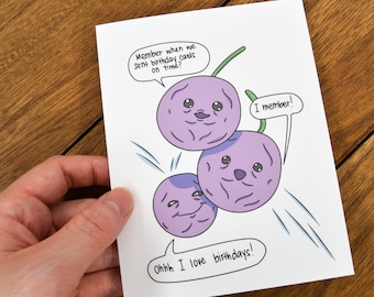 May include: A greeting card with a cartoon illustration of three purple grapes with faces. The text on the card reads "Member when we sent birthday cards on time?" and "I member!" and "Ohhh I love birthdays!"