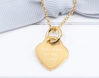 May include: Gold heart necklace with a delicate chain and a heart-shaped pendant engraved with the words "Apart is a distance but never in heart".