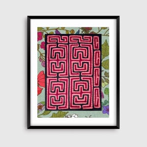 May include: Framed artwork featuring a geometric design in red and black on a teal background. The artwork is framed in a black frame and set against a floral patterned background with pink, purple, and green elements.