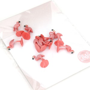 May include: A collection of pink flamingo cake toppers. The toppers are made of plastic and have a realistic design. They are perfect for adding a tropical touch to your next party.