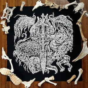 May include: A black patch with a white detailed illustration of a creature with wings, holding a sword. The creature has many eyes and appears to be a combination of a dragon and a spider. The background is black.