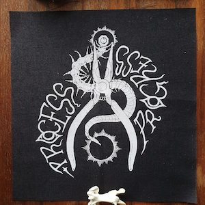 Könnte beinhalten: Schwarzer Patch mit einem weißen Design einer Zange mit einem Tausendfüßler, der sich darum wickelt. Der Text "ARCHES" und "SCYLLA" ist um die Zange herum geschrieben.