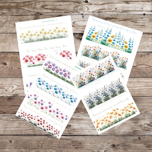 May include: Several white paper sheets with watercolor floral designs and script text. The floral borders feature various flowers in shades of yellow, blue, purple, pink, and orange. The text includes inspirational quotes and phrases.