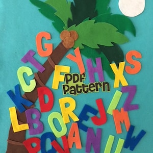 May include: A felt alphabet set with letters in various colors, arranged around a brown felt palm tree trunk with green felt leaves. The letters are arranged in a random order, and the palm tree is set against a turquoise background. The text "PDF Pattern" is visible on a yellow felt tag.