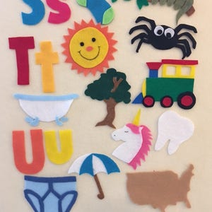 May include: Felt craft letters S, T, and U, along with various felt images including a sock, sun, spider, tree, train, bathtub, unicorn, tooth, umbrella, underwear, and the outline of the United States.