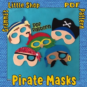 Puede incluir: Cinco máscaras de pirata de fieltro con agujeros para los ojos. Las máscaras son de diferentes colores y diseños, incluyendo un pirata azul con una calavera y huesos cruzados, un pirata verde con un loro, un pirata rojo con una bandana, un pirata azul con un pendiente dorado y un pirata marrón con bigote. Las máscaras están sobre un fondo azul con el texto "Little Shop", "Grandma's", "PDF Pattern", y "Pirate Masks" en letras amarillas.