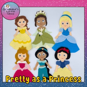 Puede incluir: Seis recortes de fieltro de diferentes princesas, incluyendo Cenicienta, Blancanieves, Bella, Jasmine, Ariel y Tiana. Las princesas llevan todas sus vestidos característicos y tienen el pelo peinado a su manera. El texto "Pretty as a Princess" está escrito en amarillo en la parte inferior de la imagen.
