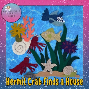 May include: A felt ocean scene with a blue background, featuring a shark, fish, starfish, and various sea plants. Two red hermit crabs and a snail are also present. The text "Hermit Crab Finds a House" is at the bottom.