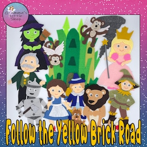 Puede incluir: Personajes de fieltro de la historia del Mago de Oz, incluyendo a Dorothy, el Espantapájaros, el Hombre de Hojalata, el León Cobarde, la Bruja Mala del Oeste y el Mago. Los personajes están dispuestos frente a un castillo de fieltro verde con un camino de ladrillos amarillos.