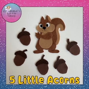 Puede incluir: Una ardilla de fieltro marrón con ojos grandes y una cola tupida, rodeada de cinco bellotas de fieltro marrón. El texto "5 Little Acorns" está escrito en letras amarillas en la parte inferior de la imagen.