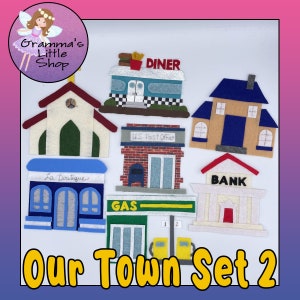 May include: Felt play set of eight buildings for pretend play. The buildings include a church, diner, post office, bank, gas station, and two shops. The set is titled "Our Town Set 2".