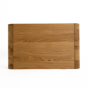 May include: A light brown wooden headboard with a curved top edge.