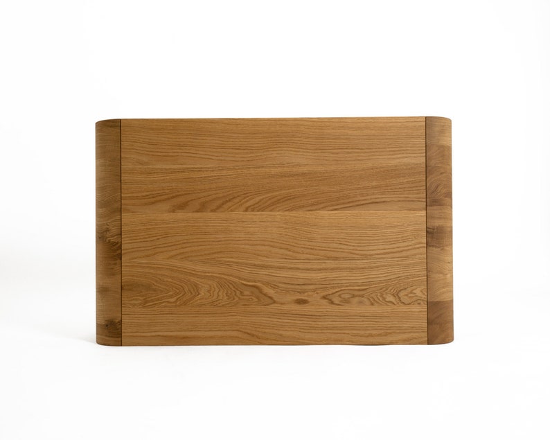 May include: A light brown wooden headboard with a curved top edge.