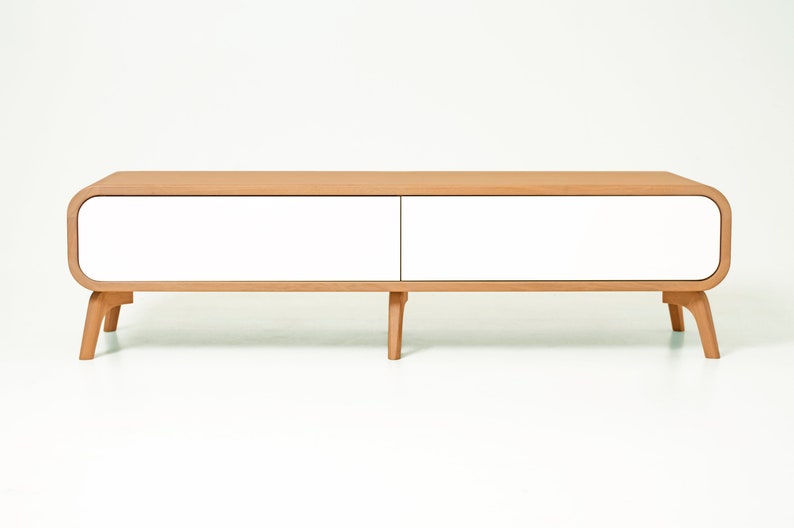 May include: A white and natural wood media console with two drawers and rounded edges. The console has four legs and a modern design.