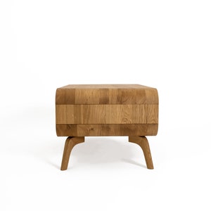 May include: A wooden coffee table with a unique, segmented top and curved, rounded legs. The table is made of light brown wood and has a natural finish.