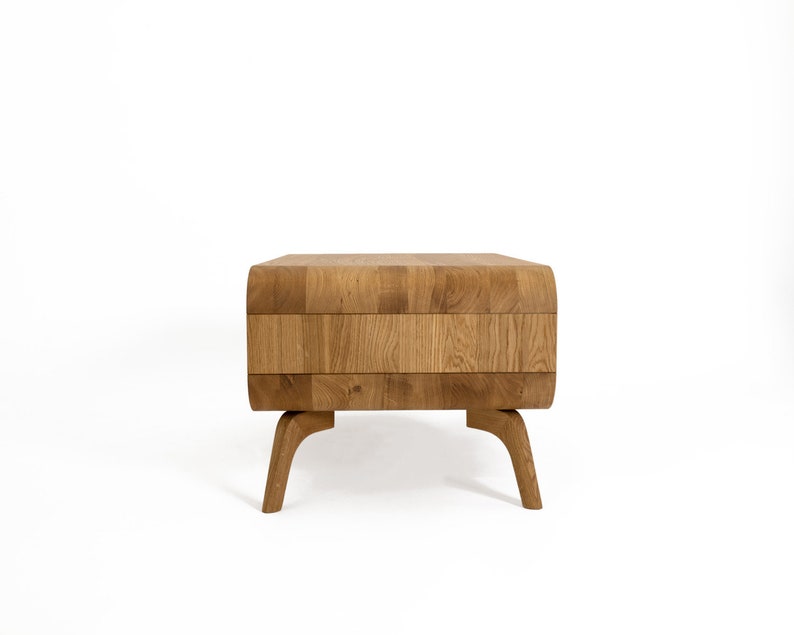 May include: A wooden coffee table with a unique, segmented top and curved, rounded legs. The table is made of light brown wood and has a natural finish.