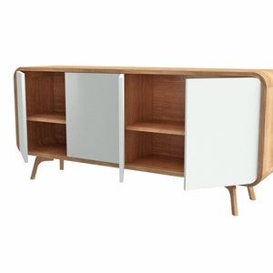 May include: A wooden sideboard with white doors and two shelves. The sideboard has rounded edges and curved legs.