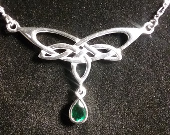 May include: A silver Celtic knot necklace with a teardrop-shaped green gemstone pendant.