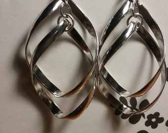 Op de afbeelding: Zilveren oorhangers met een gedraaid, verweven ontwerp. De oorhangers zijn gemaakt van metaal en hebben een gepolijste afwerking.