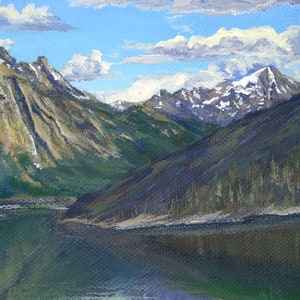 May include: Oil painting of a mountain landscape with a lake. The artwork depicts snow-capped peaks, green hills, and a calm lake reflecting the sky. The sky is blue with fluffy white clouds.