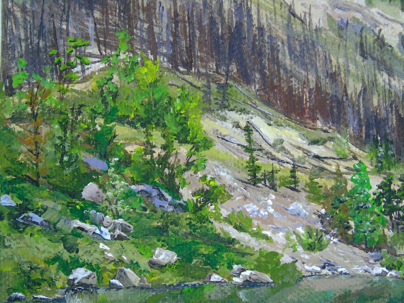 May include: An acrylic painting of a mountain landscape. The scene depicts a rocky hillside with patches of green vegetation and small trees. A dark forest is visible on the right side of the painting. The bottom of the painting shows a body of water.