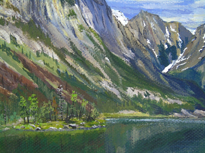 May include: An oil painting depicts a mountain landscape with a lake. The mountains are painted in shades of gray, green, and brown, with patches of snow. The lake reflects the mountains and sky, creating a serene scene.