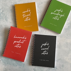May include: Four spiral bound notebooks with different coloured covers and handwritten titles. The notebooks are titled "noah's travel notes", "joshi's sourdough notes", "hannah's product notes", and "joshi's excel notes".