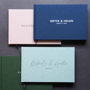 Puede incluir: Cuatro libros de visitas diferentes con varios colores y nombres. Los libros de visitas est&aacute;n hechos de un material de tela texturizada. Los nombres en los libros son "Bryce & Helen", "Mikala & Hunter", "Heather & John" y "Barbara & David".