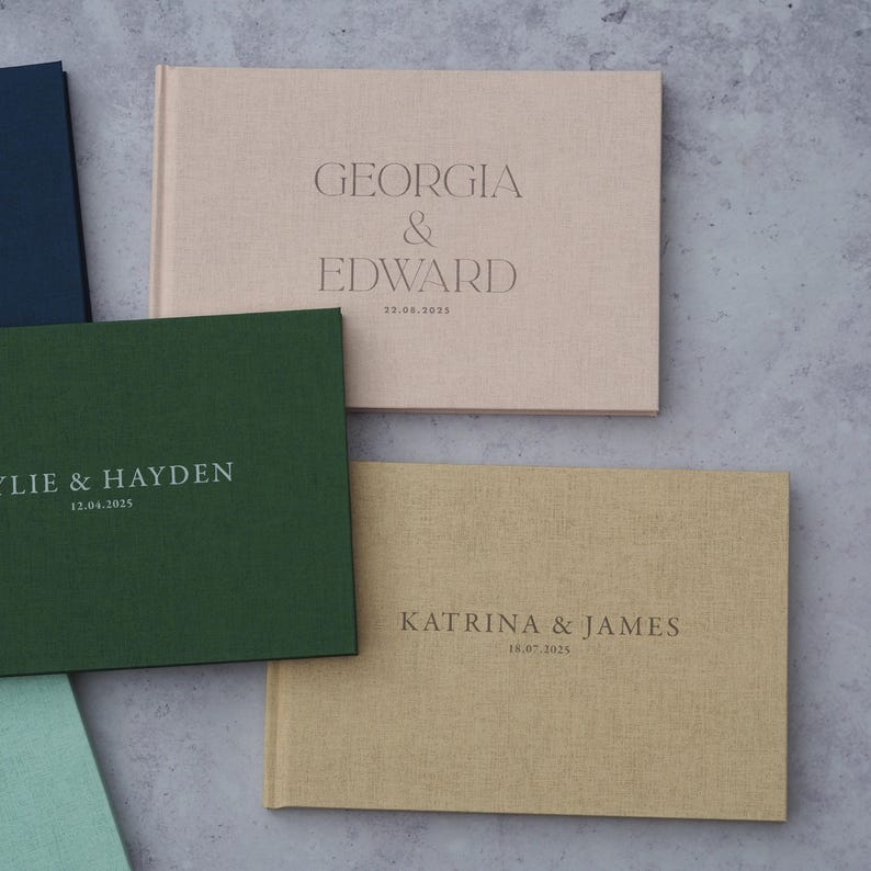 Puede incluir: Tres libros de visitas de diferentes colores con los nombres de las parejas y sus fechas de boda. Los libros son verde, beige y rosa. El texto est&aacute; en una fuente minimalista.