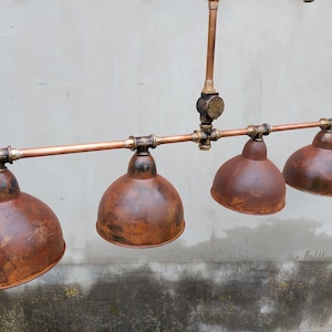 Industrial rustic pendant light for a kitchen island. Hanging rusty chandelier for a steampunk farmhouse.