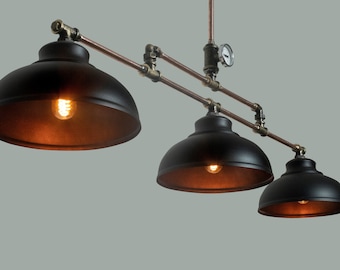 May include: A three-light industrial style pendant light fixture with black metal shades and copper pipes. The fixture has a vintage-inspired design with a gauge on the top.