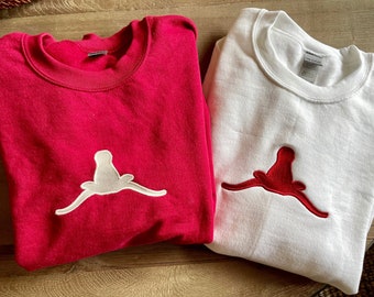 May include: Two sweatshirts, one red with a white embroidered steer head and one white with a red embroidered steer head.
