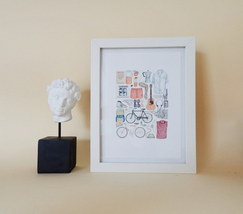 Pode incluir: Uma impress&atilde;o emoldurada branca com uma ilustra&ccedil;&atilde;o em aquarela de uma bicicleta, um viol&atilde;o, uma cafeteira, um copo de suco de laranja, &oacute;culos de sol, uma mochila e outros itens. A impress&atilde;o est&aacute; pendurada em uma parede bege claro ao lado de um busto de gesso branco de um homem.