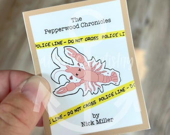 May include: A sticker featuring a cartoon illustration of a dead crawfish with a yellow police line tape around it. The text "The Pepperwood Chronicles" is at the top of the sticker. The text "by Nick Miller" is at the bottom of the sticker.