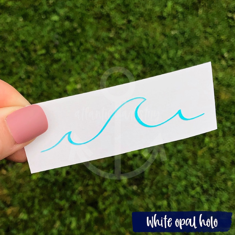 May include: A white sticker with a blue wave design. The sticker has a holographic finish and says "White opal holo" at the bottom.