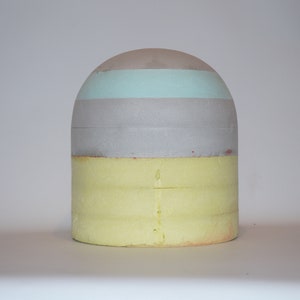 Cappello a forma di blocco con sommità arrotondata, altezza 14-26 cm.
