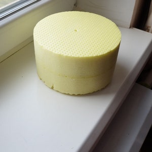 May include: A yellow foam circle with a small hole in the centre. The foam is textured with small holes.