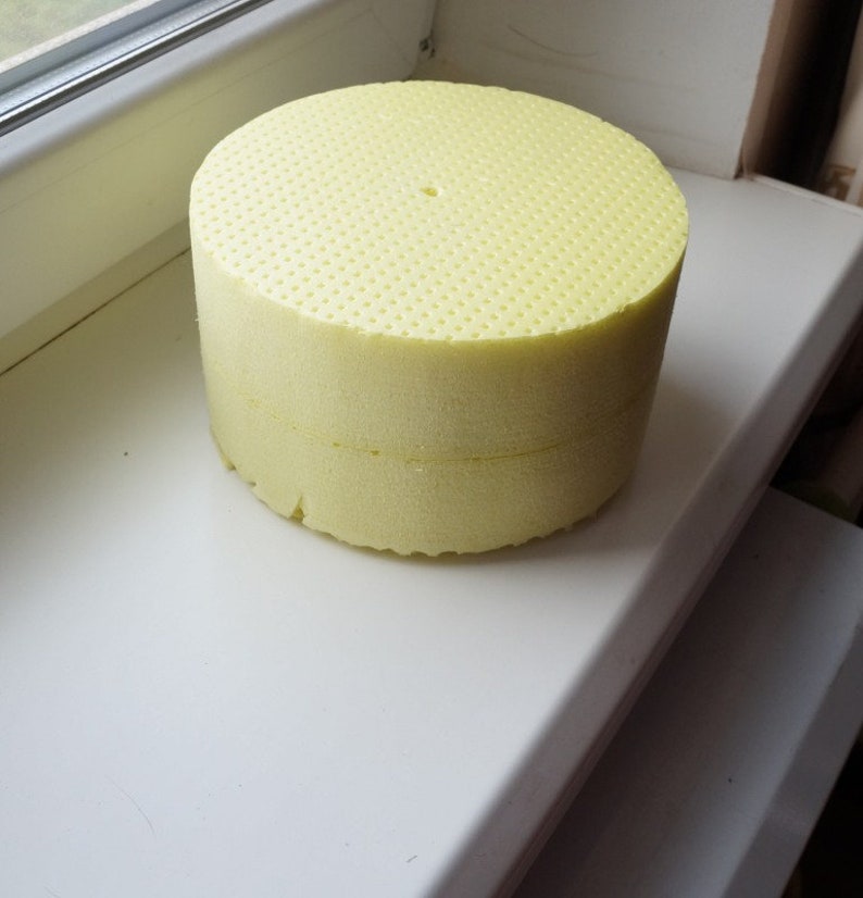 May include: A yellow foam circle with a small hole in the centre. The foam is textured with small holes.