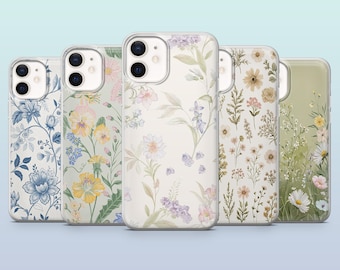 Op de afbeelding: Vijf telefoonhoesjes met bloempatronen. De ontwerpen omvatten blauwe, gele en paarse bloemen, evenals delicate botanische arrangementen. De hoesjes hebben doorzichtige randen en een lichtblauwe achtergrond.