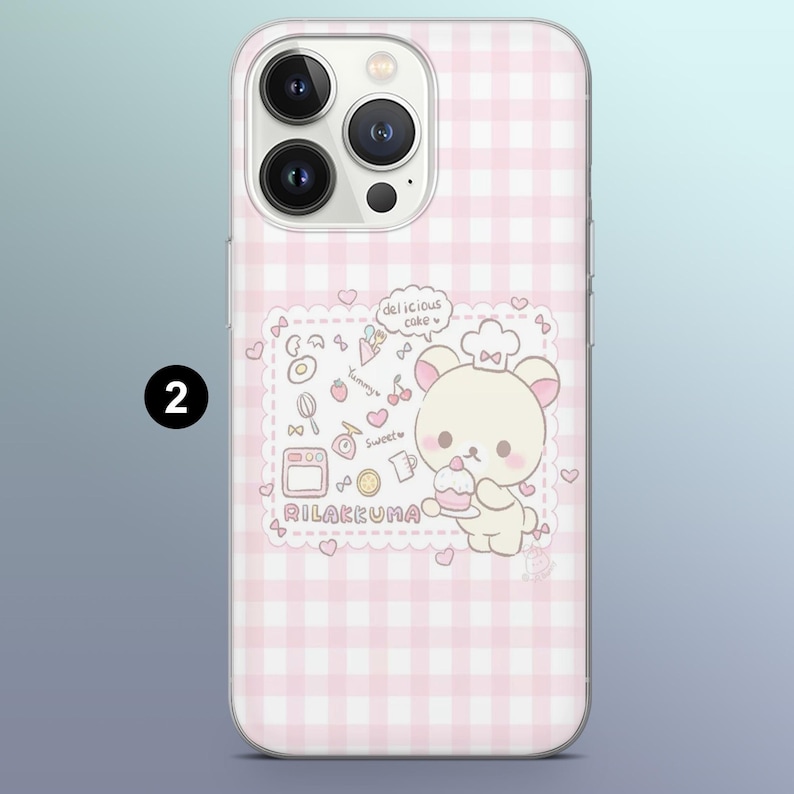 May include: Pink and white gingham iPhone case featuring a cartoon bear chef holding a cake. The case has a Rilakkuma design with the words "delicious cake", "Yummy", and "Sweet" printed on it. The number "2" is printed on the side.