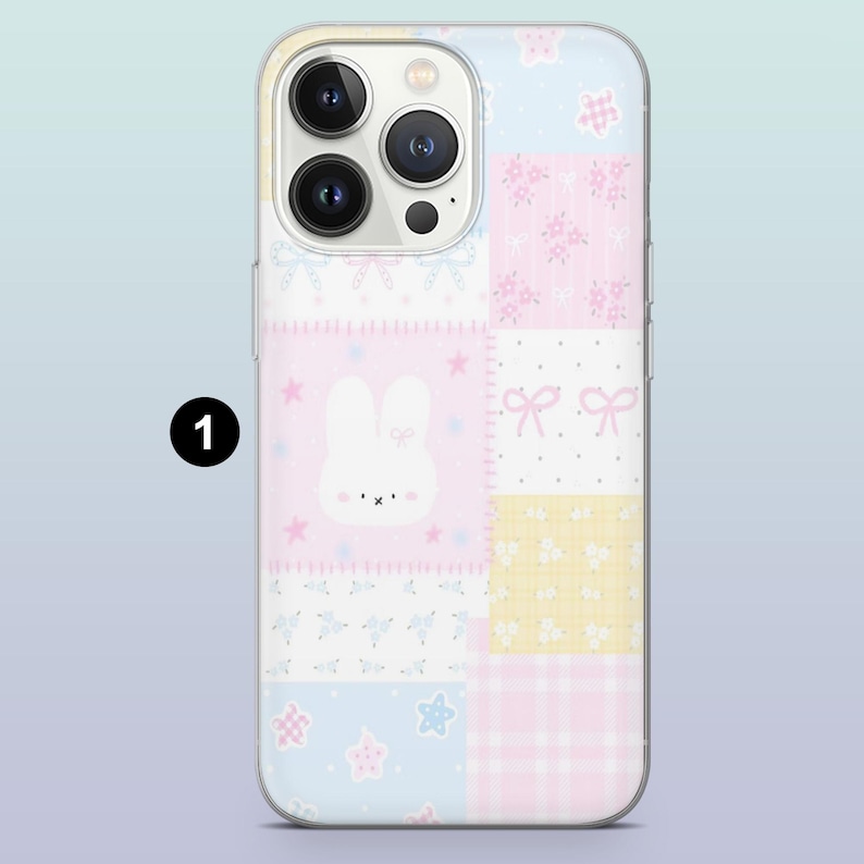 May include: A pastel-colored phone case with a patchwork design. The case features a white bunny, bows, stars, and floral patterns in pink, blue, and yellow squares. The phone case is designed to fit a smartphone.