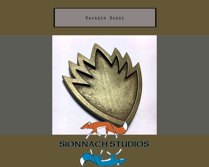 May include: A gold-colored metal Ravager badge in the shape of a stylized flame. The badge has a textured surface and is a prop from the Guardians of the Galaxy movie franchise.