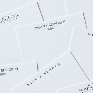 May include: A collection of white cards with black text. The cards feature the text "Beauty Bespoken", "Wild & Behold", and "Bespoken" with a small leaf design. The cards also feature the text "iamlatreuo Photography".